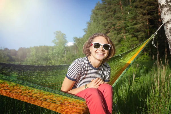 Gelukkig jonge hipster meisje geniet van leven en de natuur op een hangmat in — Stockfoto