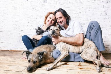 Çekici bir adam ve genç eşi evcil hayvan, iki köpek ve kedi,
