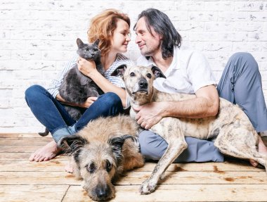 Çekici bir adam ve genç eşi evcil hayvan, iki köpek ve kedi,