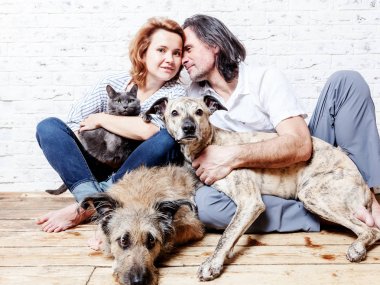 Çekici bir adam ve genç eşi evcil hayvan, iki köpek ve kedi,