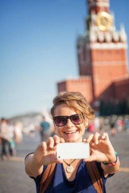 Güzel genç kadın kız hipster kırmızı Meydanı'nda selfie yapar