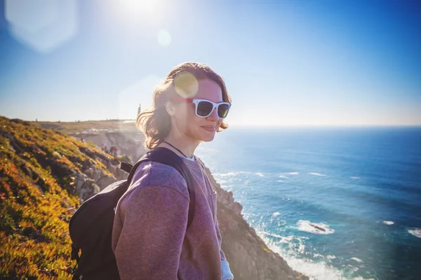 Young beautiful woman tourist with a backpack, against the backd — Stock Photo, Image