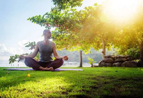 Un joven haciendo yoga en la naturaleza. Estilo de vida saludable, meditación , — Foto de Stock