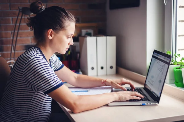 Девушка студентка фрилансер, работающая с ноутбуком на дому Windo — стоковое фото
