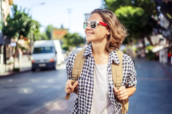 Hermosa joven en gafas de sol con una mochila en el stree —  Fotos de Stock