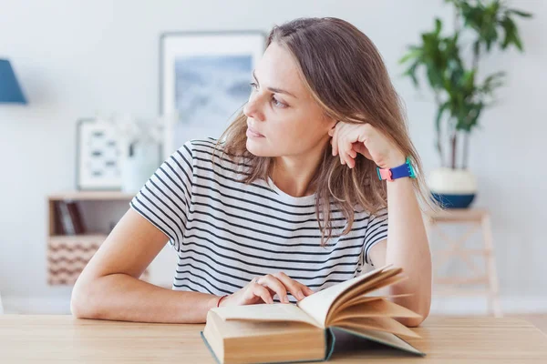 Portrait of a beautiful young stylish girl reading a book at hom — Stock Photo, Image