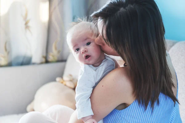 Schöne glückliche junge brünette Frau ziert ihr neugeborenes Baby in — Stockfoto