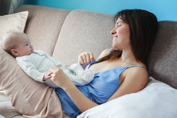 Schöne glückliche junge brünette Frau mit neugeborenem Baby auf ihrem ha — Stockfoto