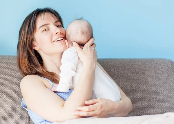 Schöne glückliche junge brünette Frau mit neugeborenem Baby auf ihrem ha — Stockfoto