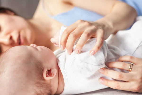 Schöne glückliche junge brünette Frau umarmt ihr neugeborenes Baby, c — Stockfoto