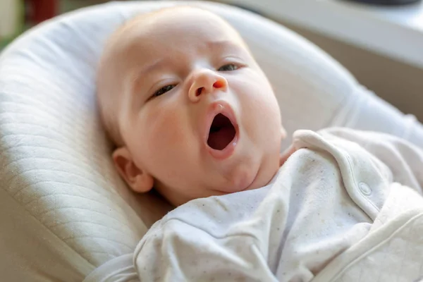 Cute newborn baby yawning lying in the cradle, a new life and fa — Stock Photo, Image