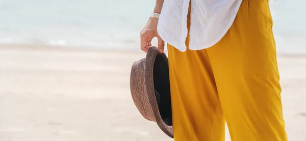 女の子で黄色のズボンに帽子を手に海岸、 vac — ストック写真