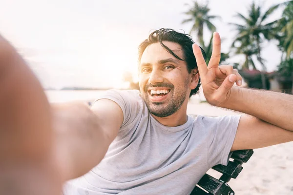 Mladý muž hipster traveler dělá selfie s výhledem na tropické — Stock fotografie