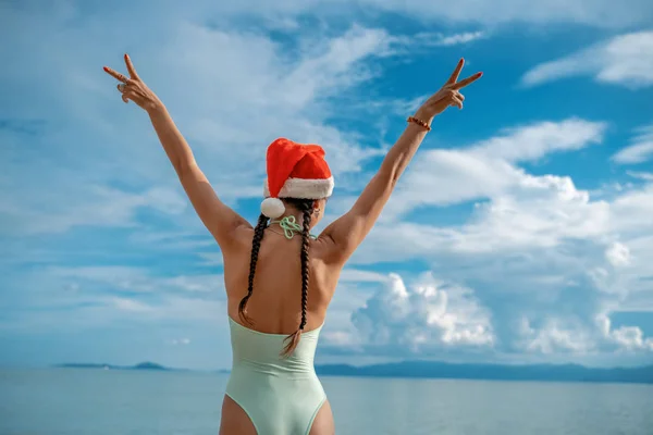 Kırmızı Noel Baba 'lı, bikinili çekici genç bir kadın. — Stok fotoğraf