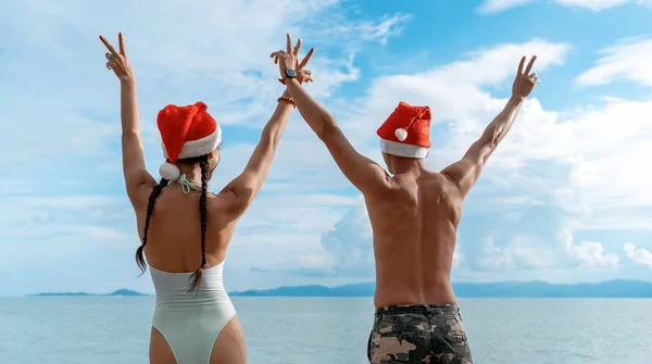 Attraktives junges schlankes Paar im Bikini mit rotem Weihnachtsmann — Stockfoto