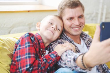 Oğlu olan genç bir baba, 8 yaşında kareli gömlekli bir çocuk.