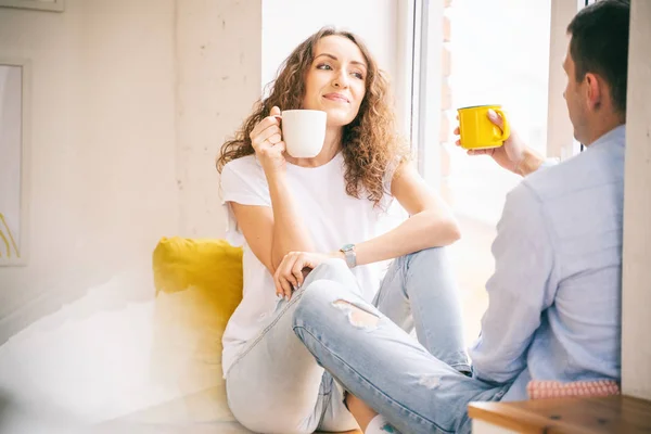 Молода щаслива пара п'є ранкову каву в своїй квартирі — стокове фото