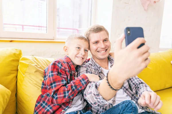 Молодий батько з сином, хлопчик 8 років у картатій сорочці — стокове фото