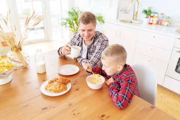 Junger Vater mit einem 8-jährigen Sohn im karierten Hemd haben br — Stockfoto