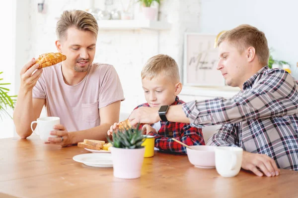 Boldog fiatal apák és fia reggelizni a konyhában, meleg f — Stock Fotó