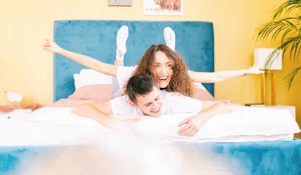Glada unga par på sängen i sovrummet ha kul, romantisk tid tillsammans — Stockfoto