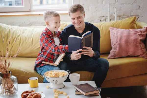 Ein junger Vater und sein Sohn ein Junge von 8 Jahren lesen Buch — Stockfoto