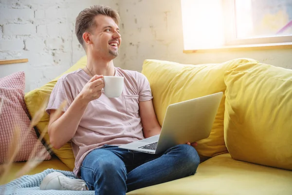 Jovem feliz com café da manhã e laptop sentado em um grito — Fotografia de Stock