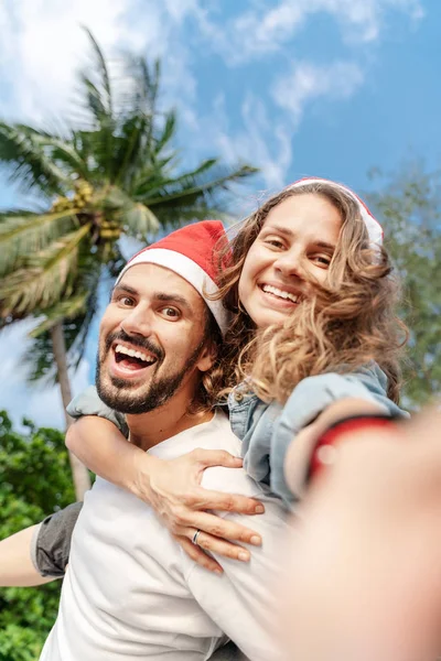 Jeune beau couple dans santa claus chapeaux fait selfie de la t — Photo