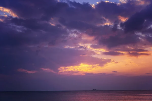 Heldere magische zonsondergang boven de zee, gouden paarse en roze tinten — Stockfoto