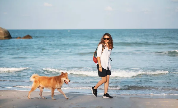 Όμορφη ευτυχισμένη γυναίκα τρέχει με το σκύλο της. Κορίτσι που απολαμβάνει το καλοκαίρι — Φωτογραφία Αρχείου