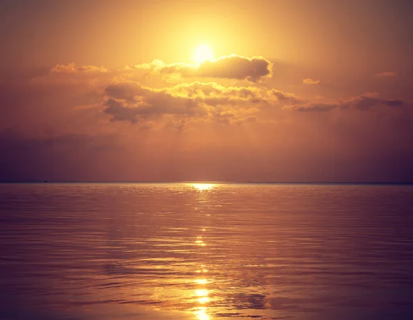 Gyönyörű arany naplemente a tengeren, a nap miatt felhők reflec — Stock Fotó