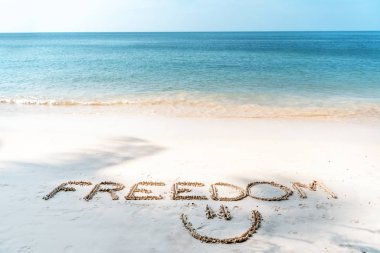 the word freedom written in the sand on a tropical beach, lifest