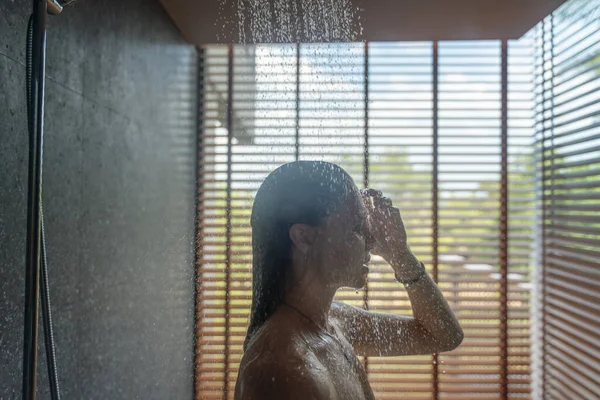 Giovane bella donna si leva in piedi prende una doccia in una camera d'albergo con — Foto Stock