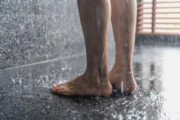 Gambe della ragazza in piedi sotto la doccia sotto il flusso di w — Foto Stock