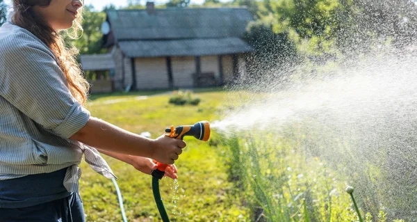 Hipster young woman watering plants a country house, summer and — Stockfoto