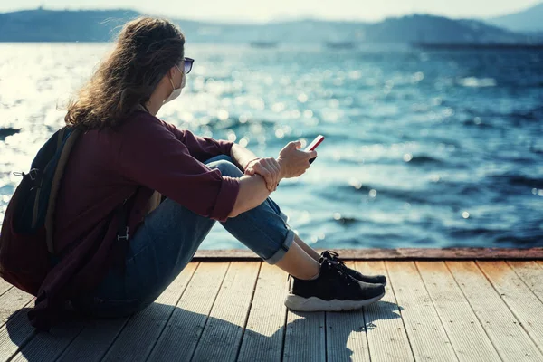 Mujer Joven Una Máscara Gafas Sol Sienta Muelle Madera Orilla —  Fotos de Stock