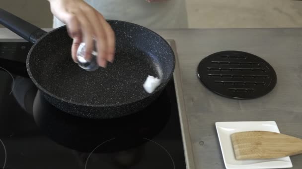 女性手将椰子油放进油锅 — 图库视频影像