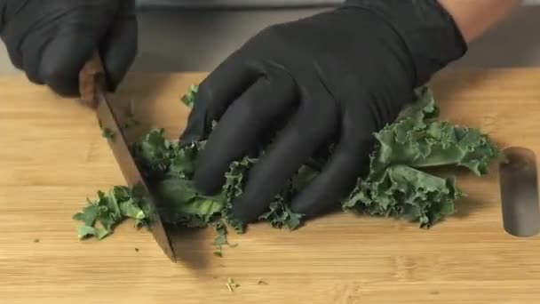 Frau Schwarzen Handschuhen Hackt Grünen Salat Auf Holztafel — Stockvideo