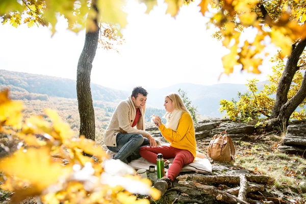 Couple in autumn forest eating and drinking — Stock Photo, Image
