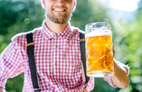 Mann in bayerischer Kleidung hält Bier in der Hand — Stockfoto