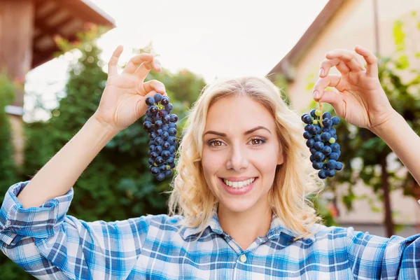 Женщина с двумя гроздьями винограда — стоковое фото