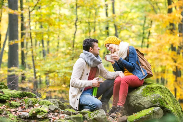 Couple in autumn forest drinking tea — Stock Photo, Image