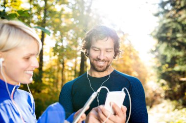 Akıllı telefonlar ve kulaklık ile çalışan çift
