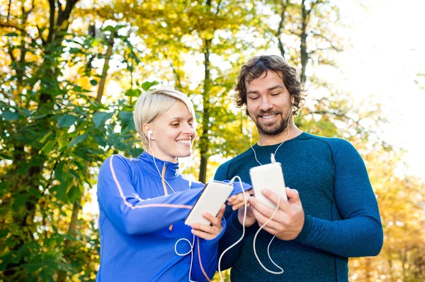 Laufpaar mit Smartphone und Kopfhörer — Stockfoto