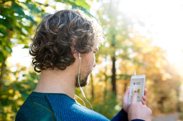 Homem correndo com telefones inteligentes e fones de ouvido — Fotografia de Stock