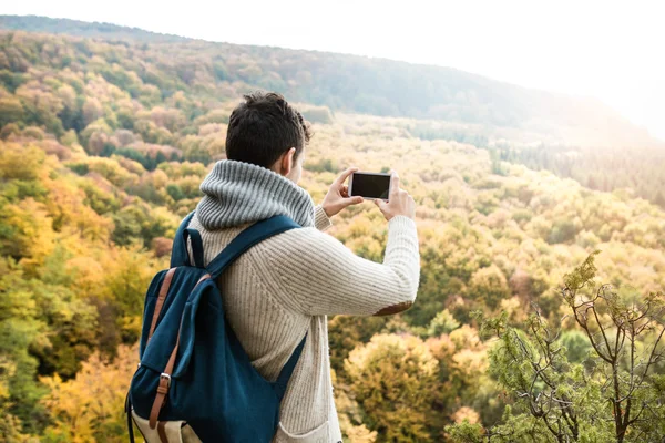 Hombre irreconocible con teléfono inteligente contra el colorido otoño por delante —  Fotos de Stock