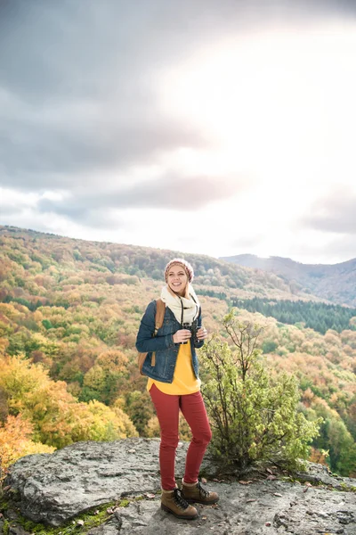Belle femme avec sac à dos contre coloré ensoleillé avant l'automne — Photo