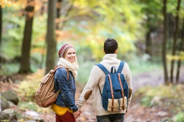 Sonbahar ormandaki bir yolda güzel Çift
