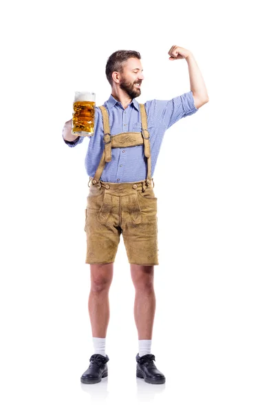 Чоловік у баварському одязі, тримає пиво, показує біцепс — стокове фото