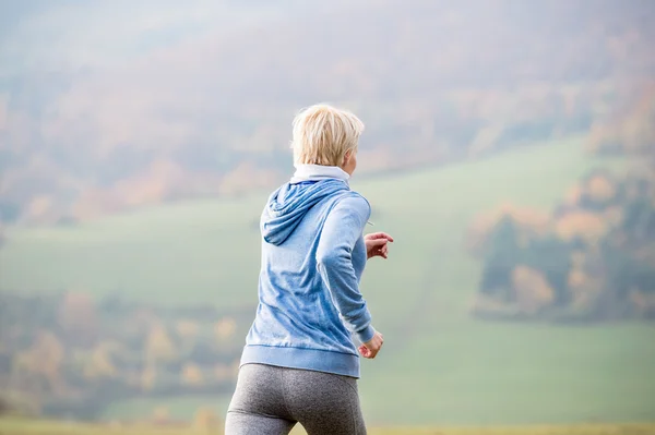 Fiatal nő fut az őszi természet, hátsó nézet — Stock Fotó
